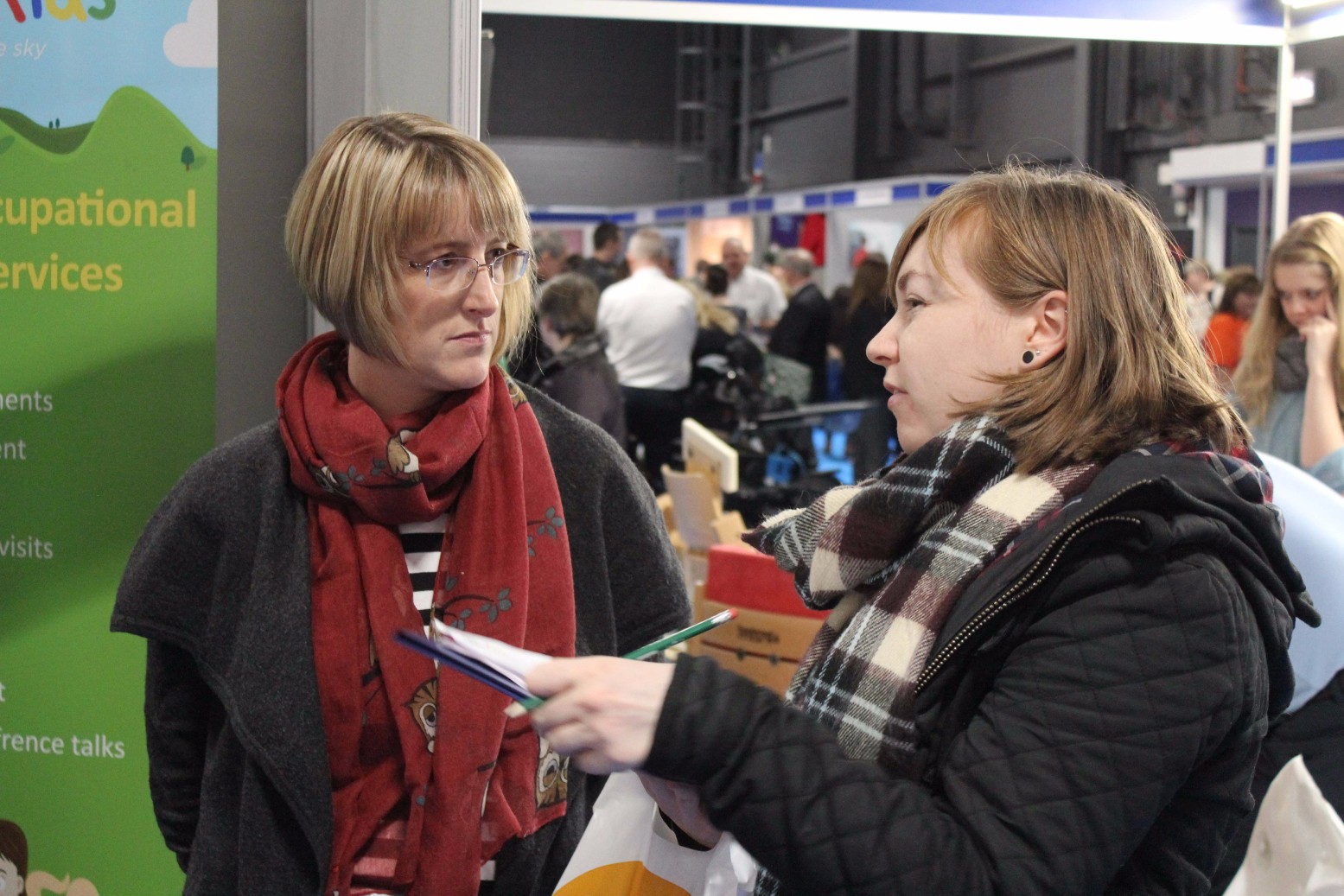 Two delegates conversing at a Therapy Expo